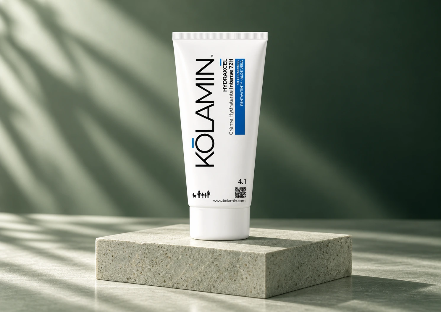 Soin Hydraxcel de Kolamin : tube blanc aux accents bleus sur un socle en pierre, dans une lumière douce et des tons verts